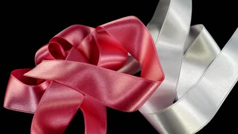 Satin-ribbon-on-a-black-background.-Slow-motion.