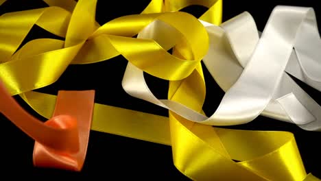 Satin-ribbon-on-a-black-background.-Slow-motion.