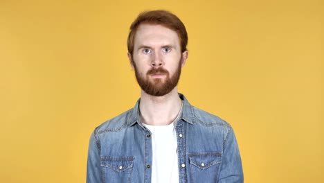 Redhead-Man-Gesturing-Thumbs-Down-Isolated-on-Yellow-Background