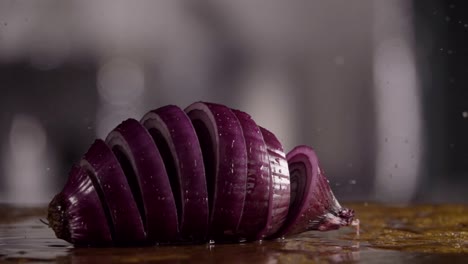 Falling-of-sliced-red-onion-into-the-wet-table.-Slow-motion-240-fps