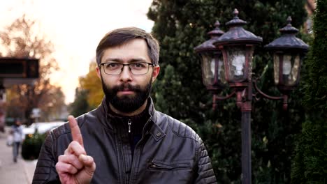 No,-beard-man-in-glasses-rejecting-offer-by-waving-finger-on-the-street