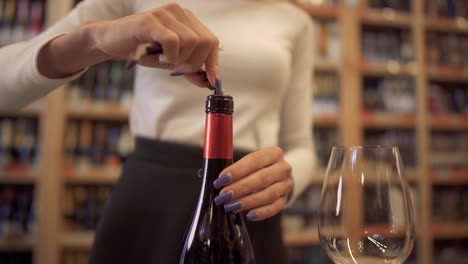 Female-hands-uncorking-a-bottle-of-wine-close-up.-Girl-uncorking-the-wine-with-a-corkscrew.