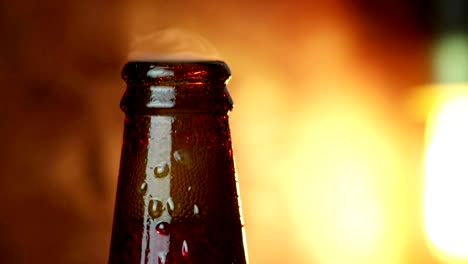 man-uncork-a-bottle-of-beer-with-foam-with-ice-frozen-drops,-on-gold-brown-background,-fun-and-nutrition-drink