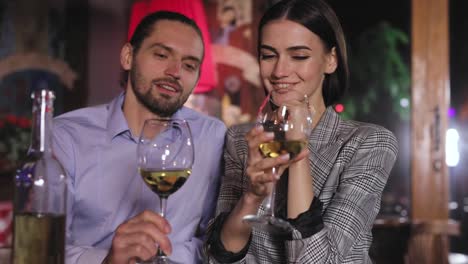 Couple-Cheering-With-White-Wine-Glasses-On-Romantic-Dinner