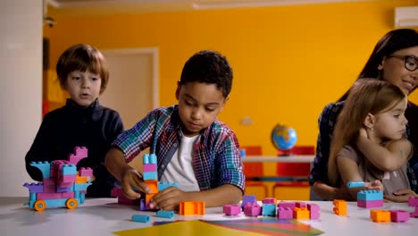 Niños-del-edificio-con-los-ladrillos-de-construcción-brillantes