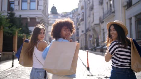 Chicas-de-compras-multinacional-sonriendo-a-cámara