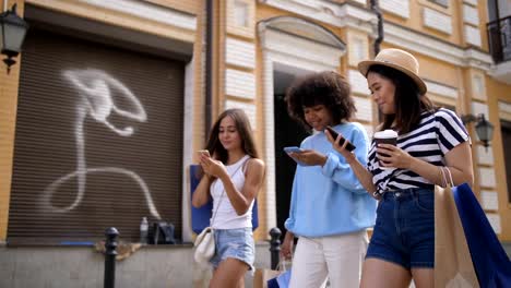 Niñas-diversas-redes-con-teléfonos-móviles-en-la-calle