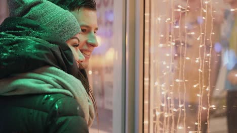 Couple-looking-at-the-showcase-in-the-street-in-the-evening