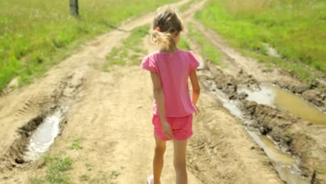 Little-girl-walking-along-a-rural-road