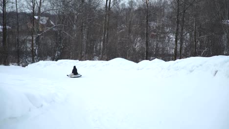 Frau-mit-Tochter-Sleedding-auf-eine-Snow-Tube