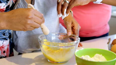 Father-and-son-pouring-flour-into-bowl-and-mother-whisking-eggs-4k