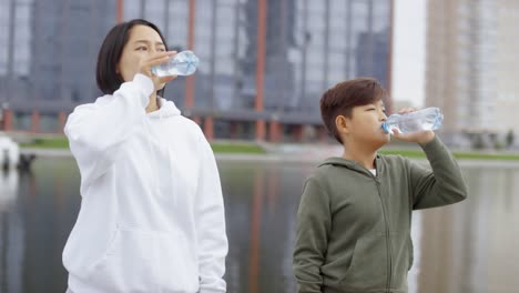 Asian-Mother-and-Son-Drinking-Water-after-Morning-Run