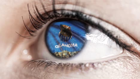 Woman-green-eye-in-close-up-with-the-flag-of-Oklahoma-state-in-iris,-united-states-of-america-with-wind-motion.-video-concept