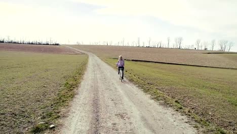 Junge,-Hübsche,-blonde-Frau-Fährt-Auf-Oldtimer-Fahrrad-Auf-Einem-feldweg