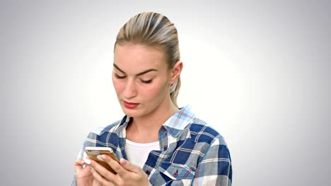 Troubled-woman-reading-bad-text-news-on-phone-touching-her-head-in-misery-on-white-background