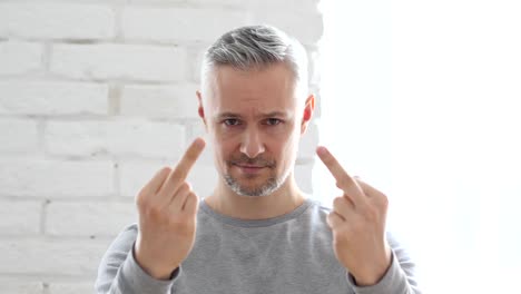 Middle-Aged-Man-Showing-Middle-Finger,-Sitting-in-Office