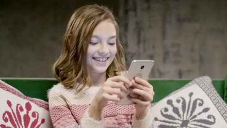 Teen-girl-chat-with-friend-by-smartphone-at-home