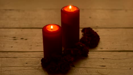 Velas-rojas-con-rosa-en-el-mostrador-de-madera-blanco