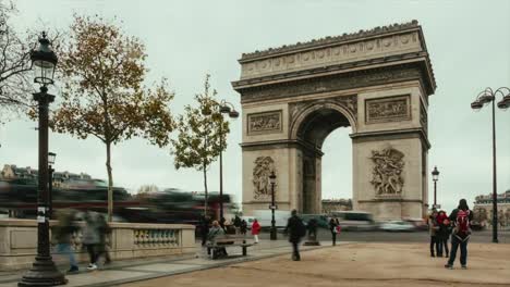 Straßenverkehr-Zeitraffer-in-der-Nähe-von-Arc-de-Triomphe-an-bewölkten-Tag-in-Stoßzeiten-in-Paris,-Frankreich.