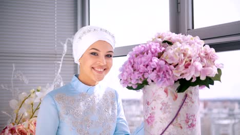 Hermosa-novia-musulmana-en-vestido-de-novia-hermoso,-que-huele-a-flores