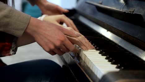 Pianista-profesional-enseña-a-estudiante-a-tocar-el-piano