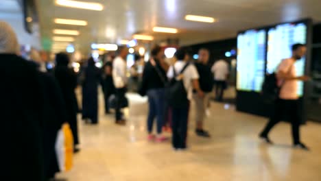 Personas-irreconocibles-borrosas-caminando-en-el-aeropuerto.-Irreconocibles-pasajeros-yendo-y-viendo-en-el-marcador-en-línea.-Fondo-Defocused-de-terminal-grande-con-los-seres-humanos-de-escalonamiento-para-el-vuelo.