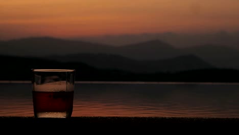 Aircraft-flying-in-dark-sky-on-background-glass-whiskey-landing-in-airport