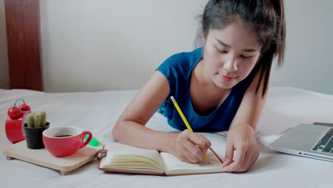 Frau-Hand-mit-Stift-schreiben-Notebook-auf-bedroom.4k-Footage