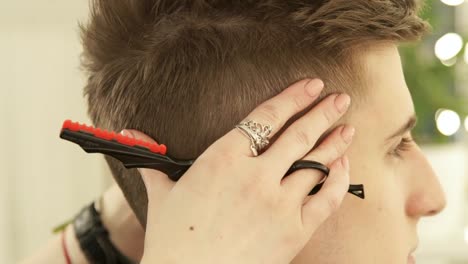 Hair-stylist-working-in-hairdressing-salon-close-up.-Hairdresser-finish-hair-style-after-cutting.-Male-hairstyle-in-barber-shop