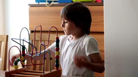 Niño-preescolar,-jugando-con-los-juguetes-en-una-habitación-soleada,-desarrollo-infantil