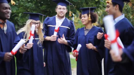 glückliche-Schüler-in-Mörtel-Boards-mit-Diplomen