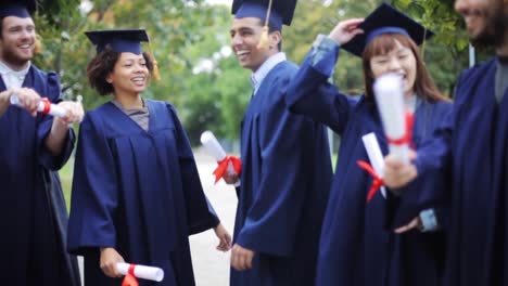 glückliche-Schüler-in-Mörtel-Boards-mit-Diplomen