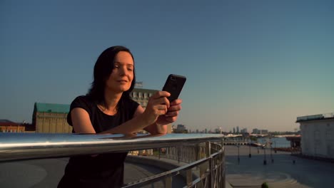 girl-is-standing-by-the-fence-and-typing-a-message