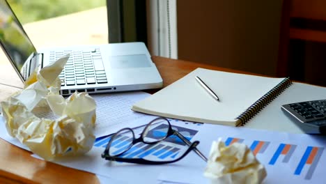 Full-HD-footage-of-work-space-background.-computer-laptop-with-paper-work-as-chart-and-graph-account-with-calculator-on-table-workplace.