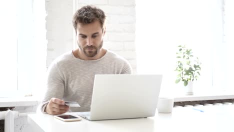 Online-Shopping-with-Bank-Card-by-Handsome-Man-on-Laptop