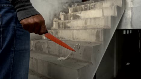 Closeup-foto-de-mano-sosteniendo-un-cuchillo-sangriento-con-sangre-goteando