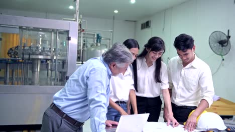 Factory-owner-inspecting-his-production-line.-Asian-senior-man-with-beautiful-asian-female-personal-assistants-and-engineer-talking-inside-factory.