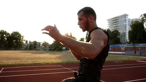 Proceso-de-un-joven-boxeador-en-el-estadio-de-formación,-elaboración-de-practicar-patadas,-kickboxing.-Usar-ropa-negra.-Sol-brilla-en-el-fondo