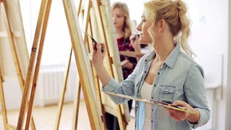 students-with-easels-painting-at-art-school