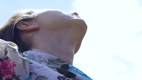 Woman-with-closed-eyes-lifting-head-up-to-sky-praying,-looking-at-skies-slow