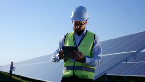 Elektrischen-Arbeiter-Tippen-auf-seinem-Tablet-außerhalb