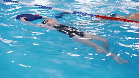 Schwimmkurse-für-Kinder-in-den-Pool---schönes-hellhäutige-Mädchen-im-Wasser-schwimmt