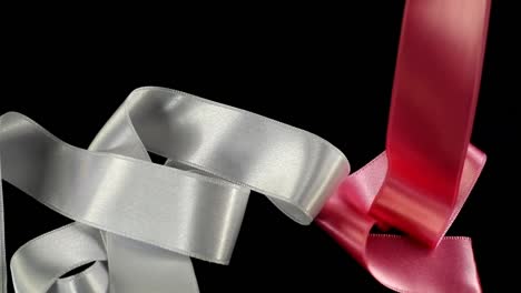 Satin-ribbon-on-a-black-background.-Slow-motion.