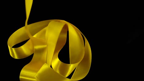 Satin-ribbon-on-a-black-background.-Slow-motion.