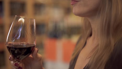 Beautiful-woman-drinking-red-wine-close-up.-Portrait-of-a-charming-lady-enjoying-a-wine-glass.