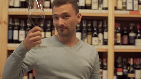 Portrait-of-man-drinking-red-wine.-Man-puts-his-glass-very-close-to-camera-and-then-tastes-alcoholic-drink.