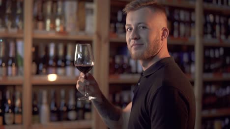 Portrait-of-handsome-male-in-profile-holding-wine-glass.-Man-admires-alcoholic-drink.