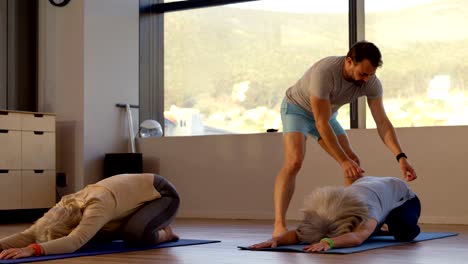 Entrenador-de-asistencia-a-senior-femenino-en-la-realización-de-yoga-4k