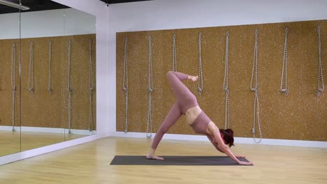 Mujer-joven-haciendo-yoga-asana-en-estudio-de-yoga