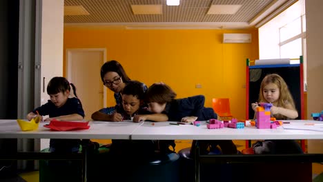 Diverse-kindergarten-pupils-learning-at-classroom
